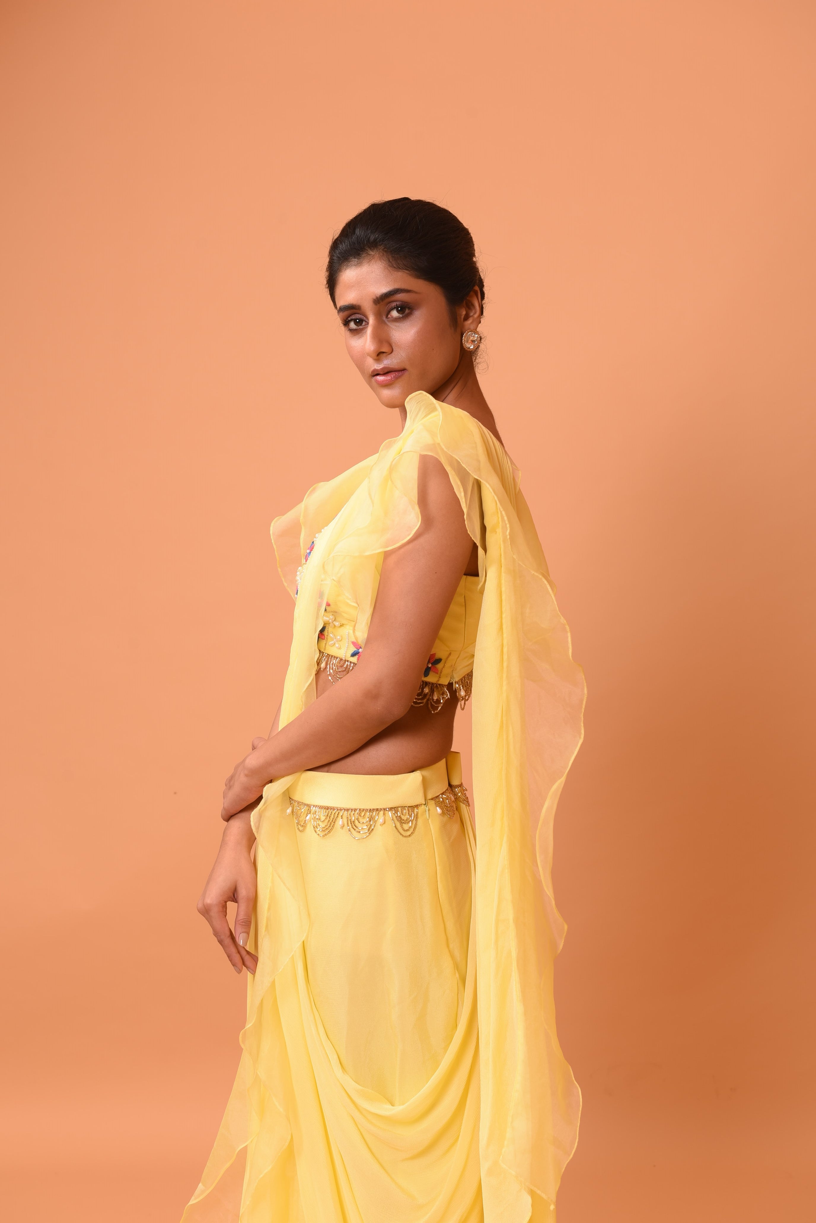 Yellow ruffle saree with lace work and embroidered blouse featuring intricate handwork.