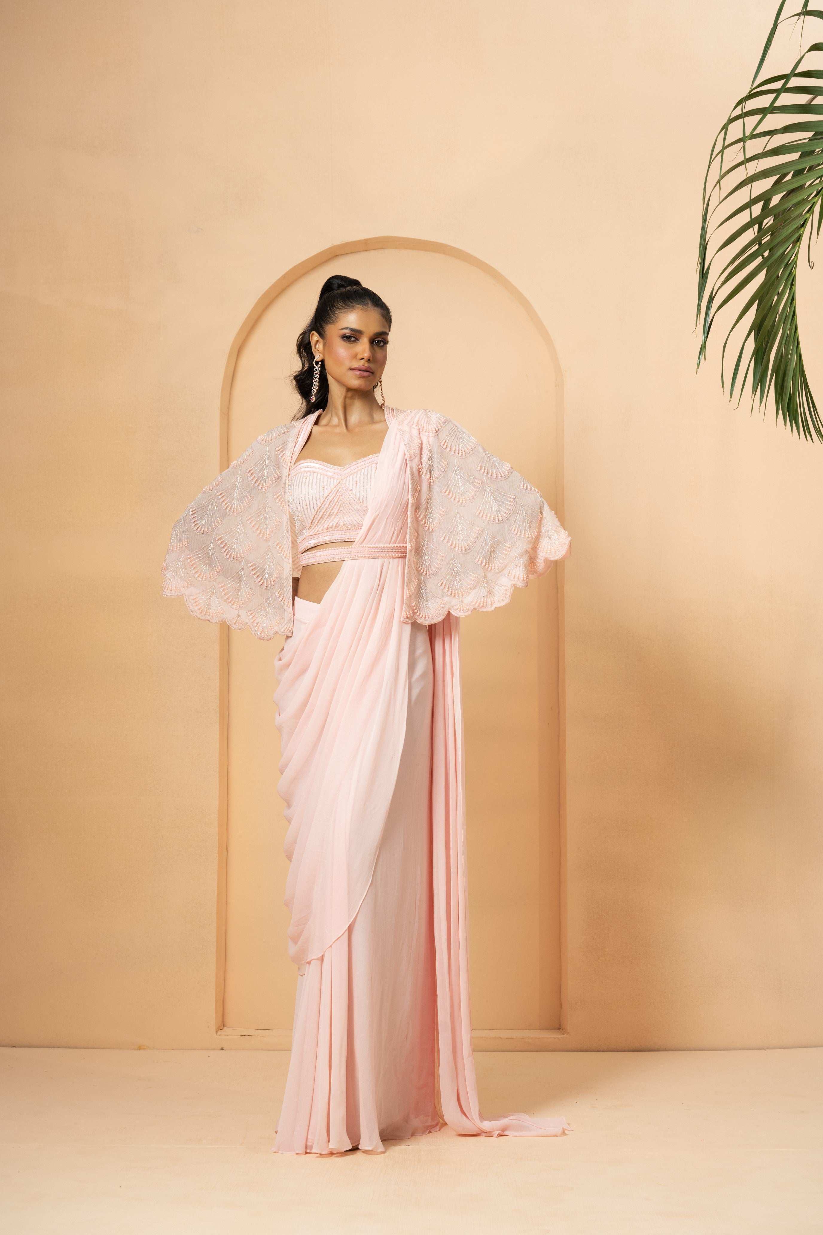 Baby pink pre-stitched drape saree with a pearl-beaded embroidered cape.