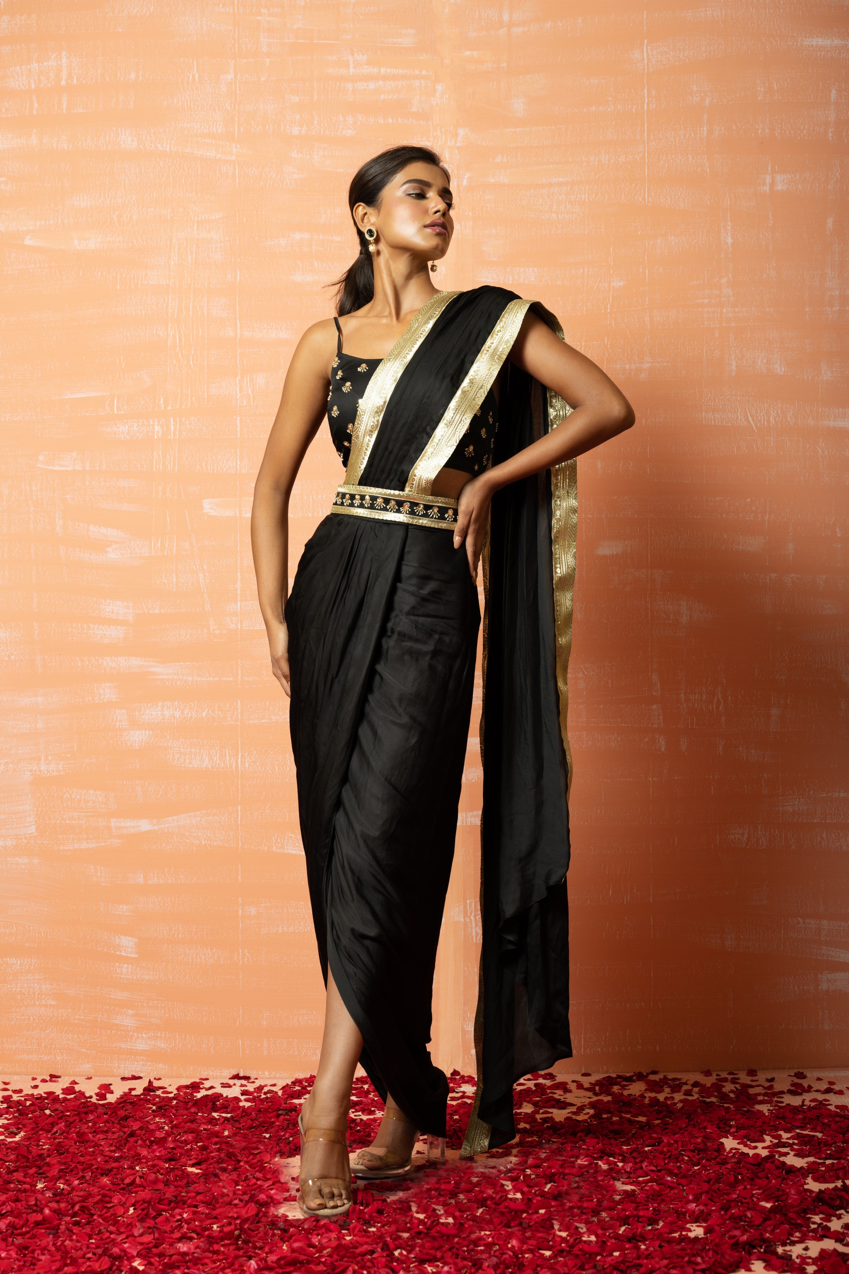 Black dhoti saree with embroidered blouse and waist belt detailing.