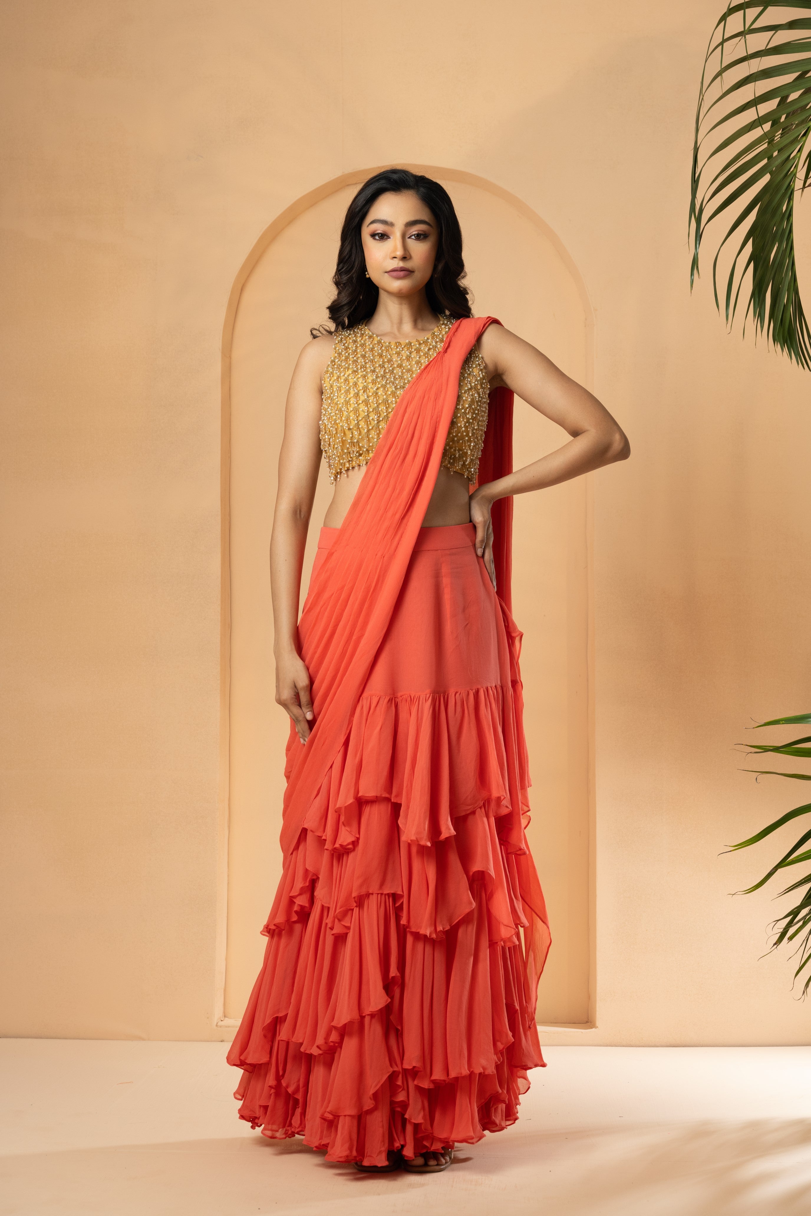 Peach pre-stitched ruffle saree with georgette and net, detailed with cutdana and beadwork.