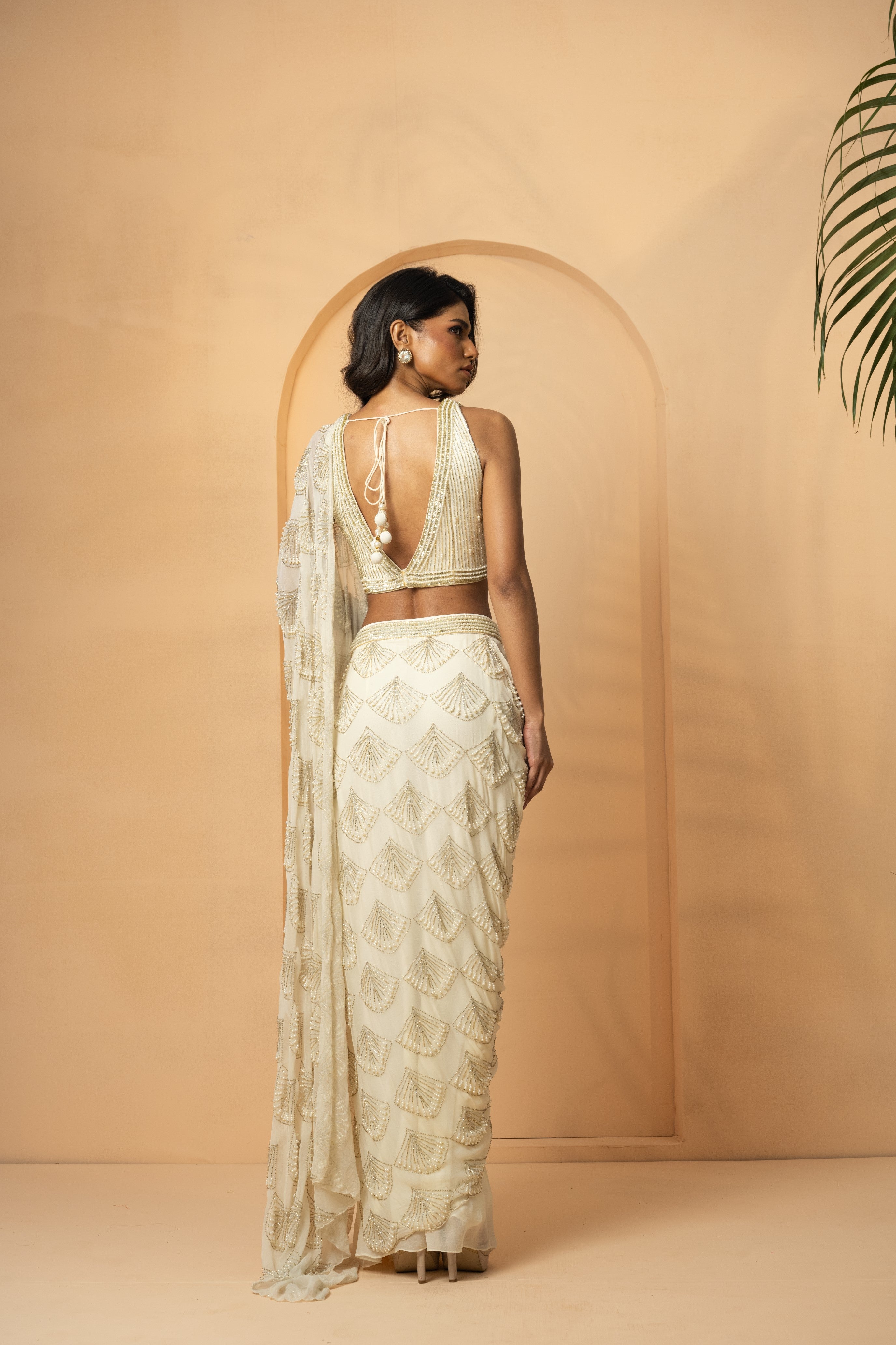 Ivory pre-stitched drape saree with intricate self-on-self embroidery.