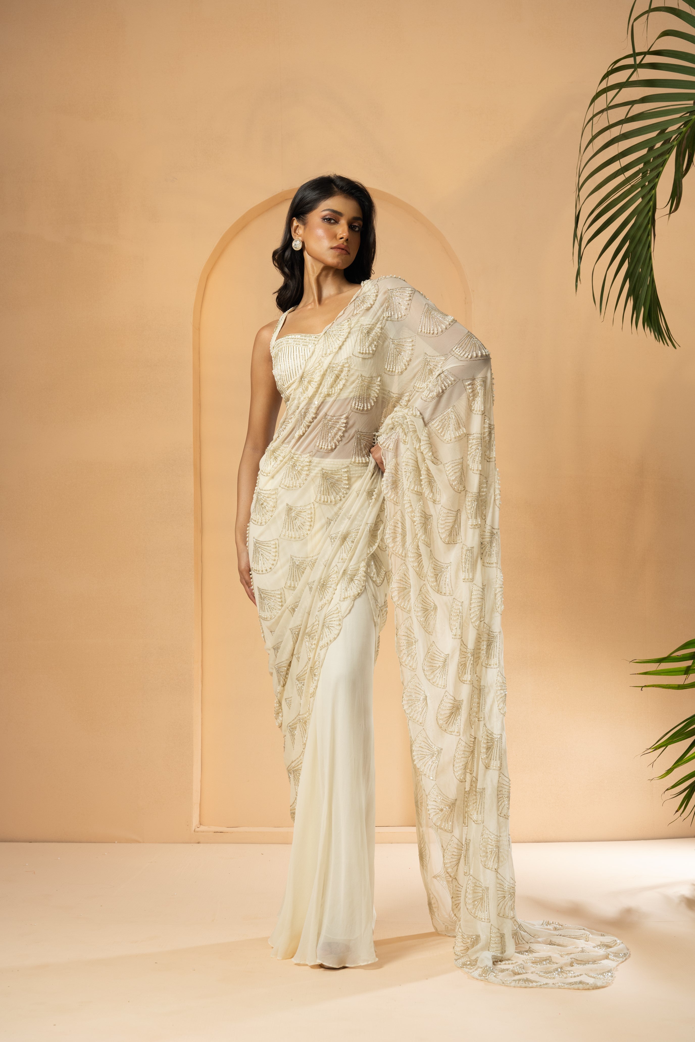 Ivory pre-stitched drape saree with intricate self-on-self embroidery.