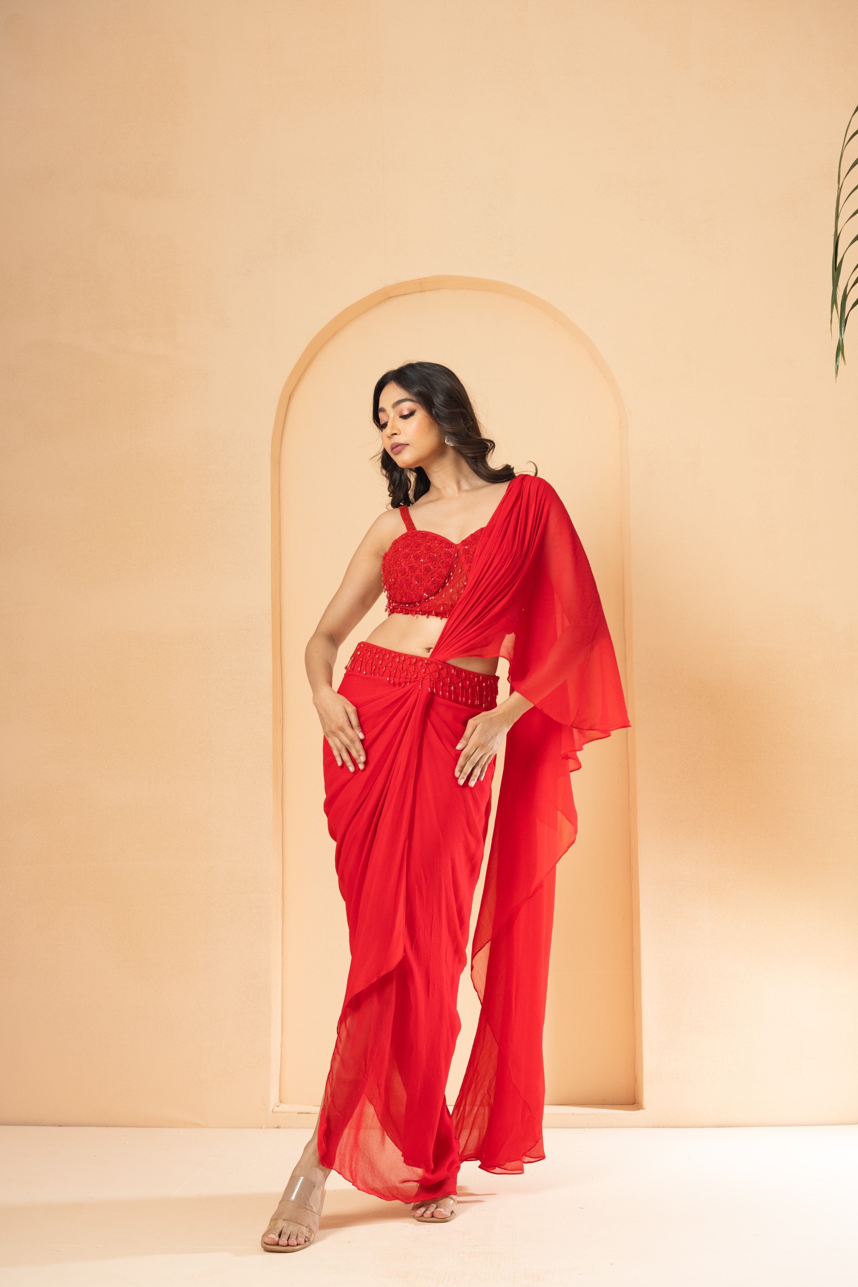 Red pre-stitched drape saree with a corset blouse and crystal bead embroidery.