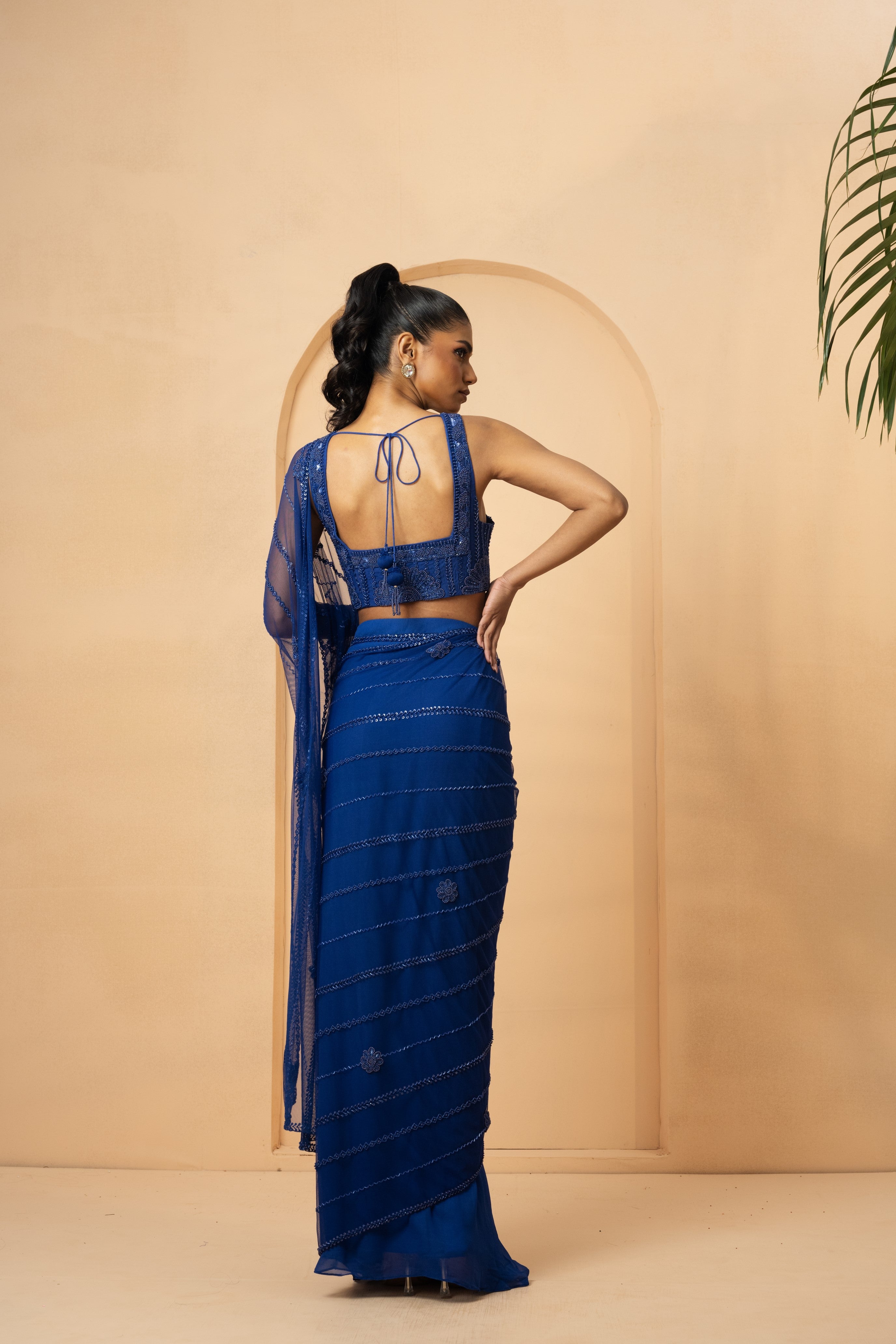 Blue drape saree with intricate self-on-self embroidery on blouse and pallu.