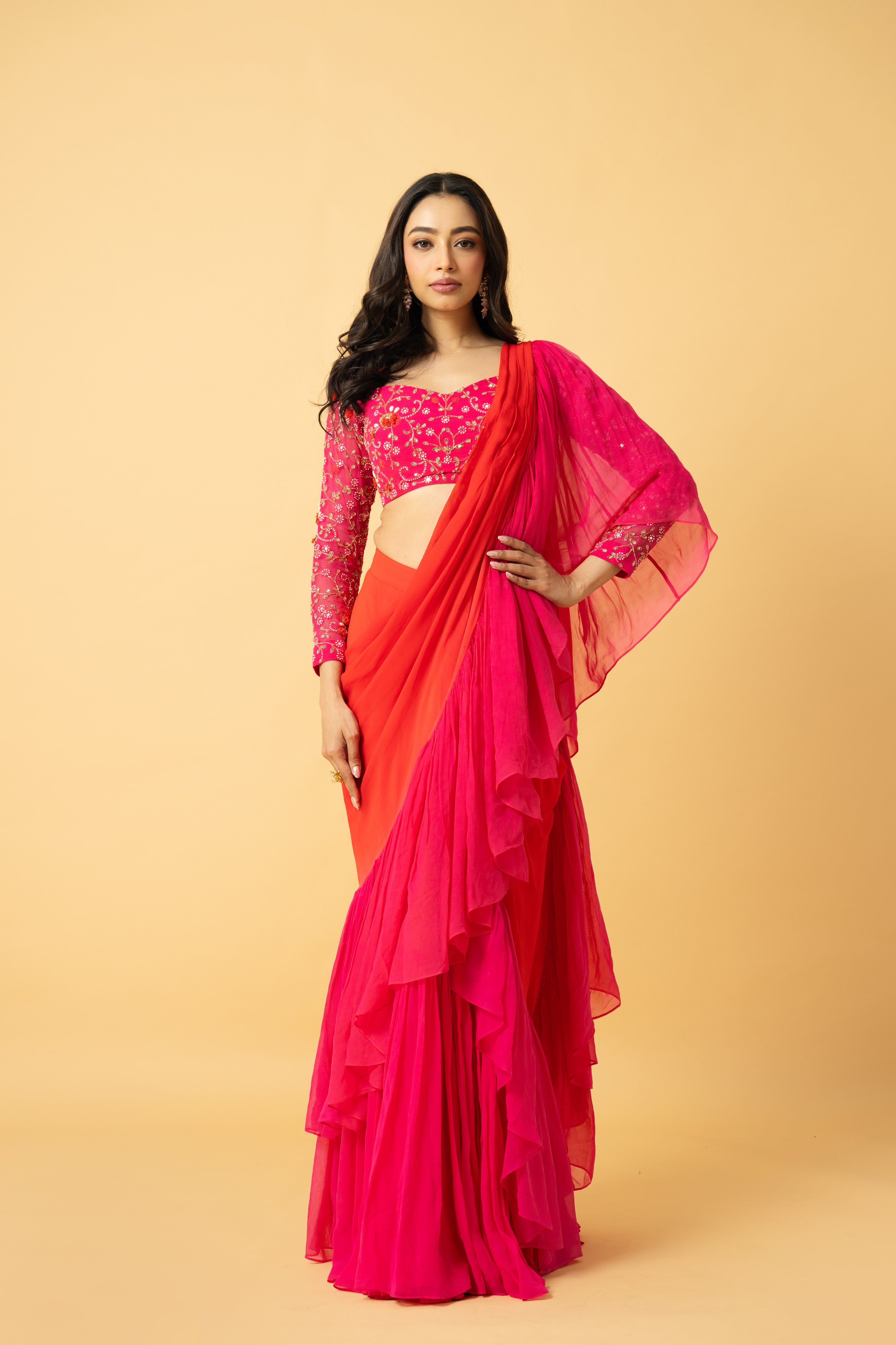 Pink and orange georgette ruffle saree with hand-embroidered full-sleeve blouse.