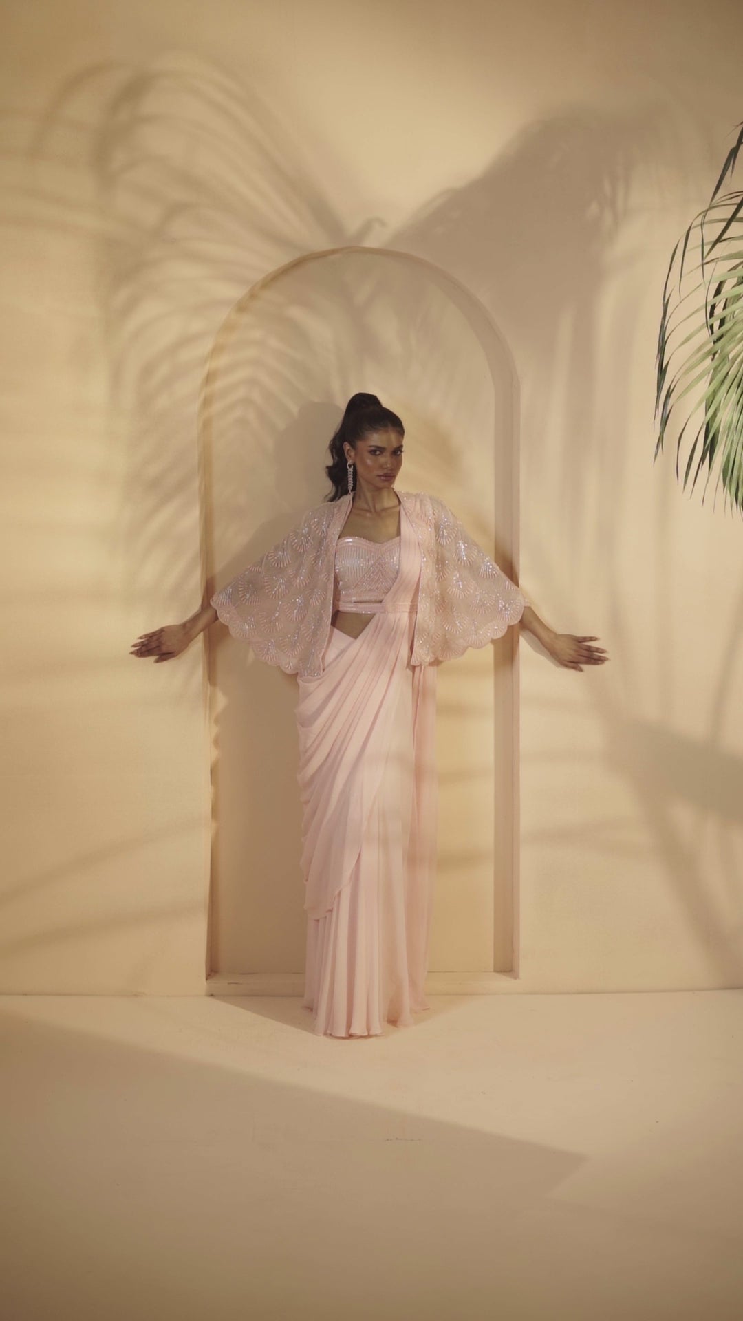 Baby pink pre-stitched drape saree with a pearl-beaded embroidered cape.